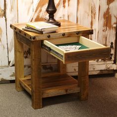 a wooden table with an open drawer on it and a lamp next to it in front of a door