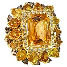 This sunshine stunning ring from S.Georgios designer was handmade in our workshop in Greece from solid 18 Karat Yellow Gold. The ring features 9.7 Carats of Faceted Citrine center surrounded by 10.1 Carats of pear-cut sapphires, a row of Brilliant Cut White Diamonds with a total weight of 0.45 Carats, and 1.38 Carats of Brown Diamonds with Black Rhodium prongs on the outer edge. The band is beautifully shaped to comfort and decorated with Yellow Sapphire hearts and brown diamonds on the sides. This is a beautiful one-of-a-kind ring. The ring is unique and outstanding in quality and is made in our workshop in Athens Greece. Frond Height: 31 mm Front Width: 27 mm 18 K gold Weight: 29.2 grams Size: 7.5 (can be custom-sized, please contact us) For a full selection of S.Georgios jewelry please Brown Diamonds, Sapphire And Diamond Ring, Sapphire Diamond Ring, Brown Diamond, Domed Ring, Black Rhodium, Athens Greece, Beast Mode, Yellow Sapphire