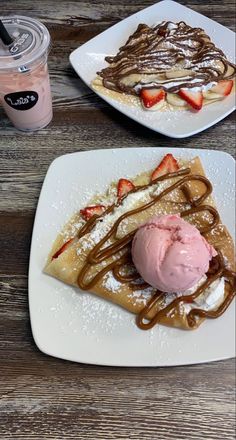 two white plates topped with waffles covered in chocolate syrup and strawberry ice cream