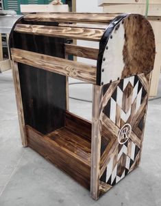 a wooden table with black and white designs on the top, sitting in a room