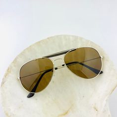 These pilot square  sunglasses feature a gold metal frame with brown glass lens. They are the perfect everyday shades. True genuine vintage sunglasses from the 90s. This style is unisex. - 400 uv  - new vintage from the 90s - includes sunglasses pouch Vintage Brown Aviator Sunglasses For Beach, Vintage Brown Aviator Sunglasses For The Beach, Vintage Aviator Sunglasses For The Beach, Gold Retro Sunglasses With Uv Protection, Retro Gold Sunglasses With Uv Protection, Gold Retro Sunglasses With Mirrored Lenses, Retro Gold Sunglasses With Mirrored Lenses, Trendy Gold Aviator Sunglasses, Gold Retro Aviator Sunglasses With Gradient Lenses