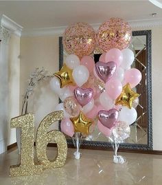 a table with balloons and numbers on it in the shape of heart shapes, sitting next to a mirror