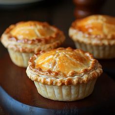 three small pies sitting on top of a wooden table