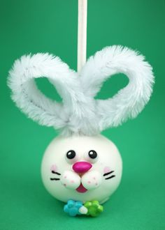 an ornament shaped like a white bunny rabbit on a green background with candy