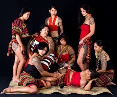 a group of women with tattoos on their bodies posing for a photo in front of a black background