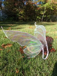 a plastic butterfly sitting on top of a lush green field