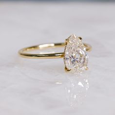 an oval cut diamond sits on top of a white surface