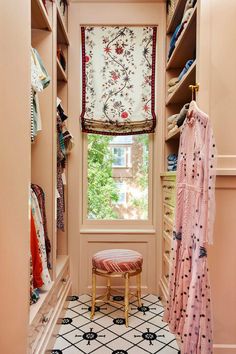 the closet is filled with clothes and other items, including a bench in front of an open window