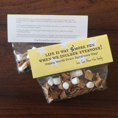 two bags filled with marshmallows sitting on top of a wooden table next to an envelope