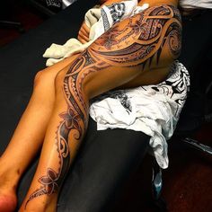 a woman with tattoos on her legs laying down