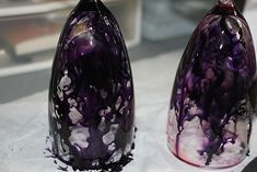 two purple vases sitting next to each other on a table