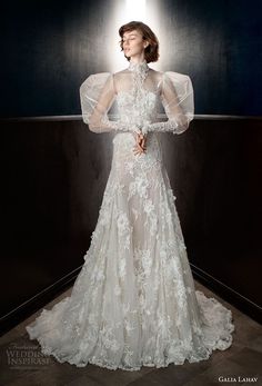 a woman in a white wedding dress with sheer sleeves