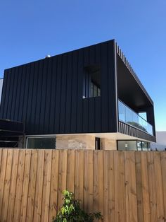 a large black building sitting on top of a wooden fence