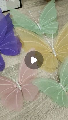 three butterflies are sitting next to each other on a table with a video player in the background