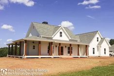 a large white house sitting on top of a dirt field