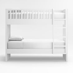 a white bunk bed sitting next to a pillow