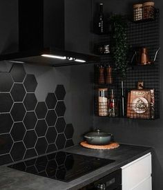 a black and white kitchen with hexagonal tiles on the wall