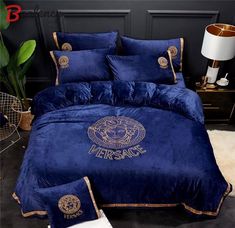 a blue comforter set with gold trimmings on the bottom, and two pillows