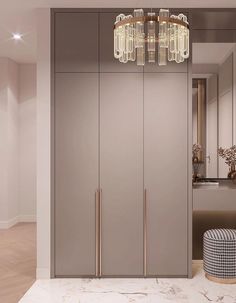 a modern closet with mirrored doors and chandelier hanging from the ceiling in an empty room