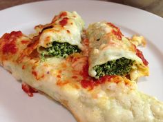 two pieces of pizza on a plate with cheese and spinach in the crusts