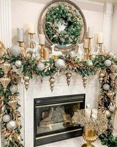 a fireplace decorated for christmas with gold and silver decorations on the mantel, wreaths and candles