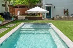 an empty swimming pool in the middle of a backyard with grass and trees around it