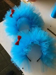 two blue wreaths with red bows are on a white table and there is an instagram post about them