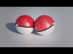 two red and white balls sitting next to each other on top of a gray surface