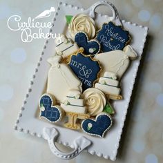 decorated cookies in the shape of teddy bears on a white plate with blue and gold accents