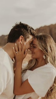 a man and woman embracing each other in the desert