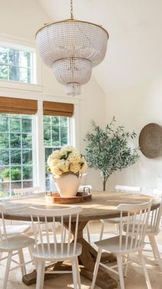 a dining room table with four chairs and a potted plant on top of it