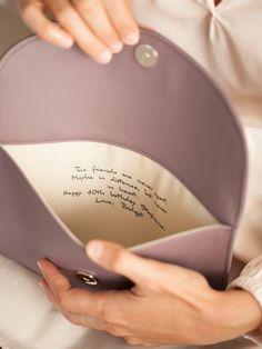 a woman is holding a pillow with writing on it and the inside of her purse