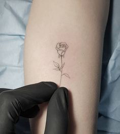 a woman's arm with a small rose tattoo on the left side of her thigh