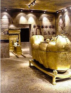 an ancient room with gold colored furniture and paintings on the walls