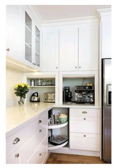 a kitchen with white cupboards and stainless steel refrigerator freezer combo in the corner