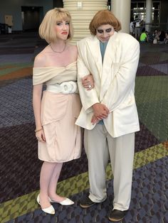 two people dressed in costumes standing next to each other on a carpeted floor,