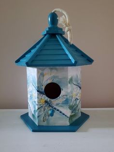 a blue birdhouse sitting on top of a white table