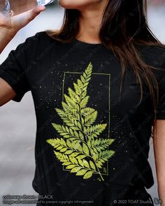 "AS A SWEATSHIRT : https://toatstudio.etsy.com/listing/1354922547 This fern leaf t-shirt is great for plant, flower, and garden lovers. Great gift for anyone who spends their time enjoying nurseries, plant shopping, and botanical gardens. FABRIC CONTENT:  - Fabric content varies based on color. Solid colors are 100% cotton, heather colors are 52% cotton/48% polyester, Athletic Heather and Black Heather are 90% cotton/10% polyester) - Light fabric (4.2 oz/yd² (142 g/m   FIT & CONSTRUCTION :  - Runs true to size (sizing runs slightly larger for women, as this is a unisex style) - Side seams help hold the garment's shape longer and give structural support - Highly elastic ribbed knit collar and neck seam helps retain neck shape  - Reinforced shoulder and neck seams stabilize the back of garme Fern Print Shirt, Botanical Style Green T-shirt With Graphic Print, Green Botanical T-shirt With Graphic Print, Botanical Green T-shirt With Graphic Print, Botanical Green Tops With Plant Print, Green Botanical Print Tops, Green Nature-inspired Crew Neck T-shirt, Fern Leaf Drawing, Forest Foliage