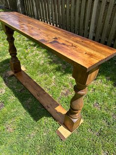 a wooden bench sitting on top of a lush green field