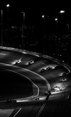 black and white photograph of cars driving down a highway at night