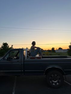 a person sitting in the bed of a truck