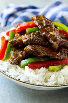 a plate full of rice and beef with peppers