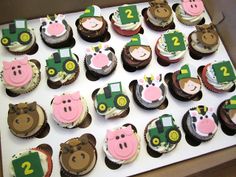 cupcakes in the shape of farm animals and tractors are on display for children to eat