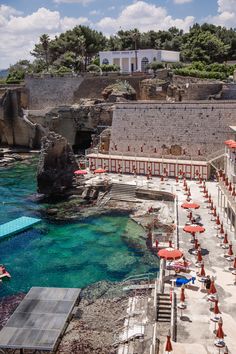 an aerial view of the beach with umbrellas and chairs on it's sides