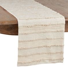 a wooden table with a white runner on it's end and a wood table top in the background