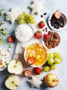 an assortment of fruits and nuts are arranged on a cutting board with star shaped candies