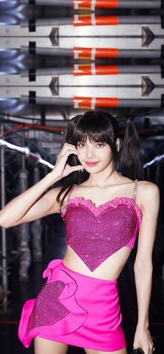 a woman in a pink dress posing for the camera with her hand on her head