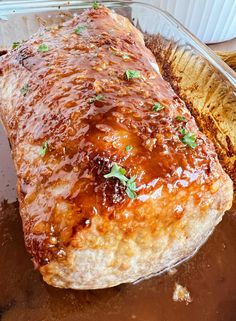 a large piece of meat covered in sauce and garnished with parsley on top