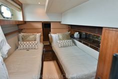 there are two beds on the inside of a boat that is parked in the water