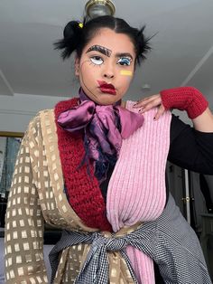 a woman with makeup on her face is holding onto a piece of clothing that has been made to look like a doll